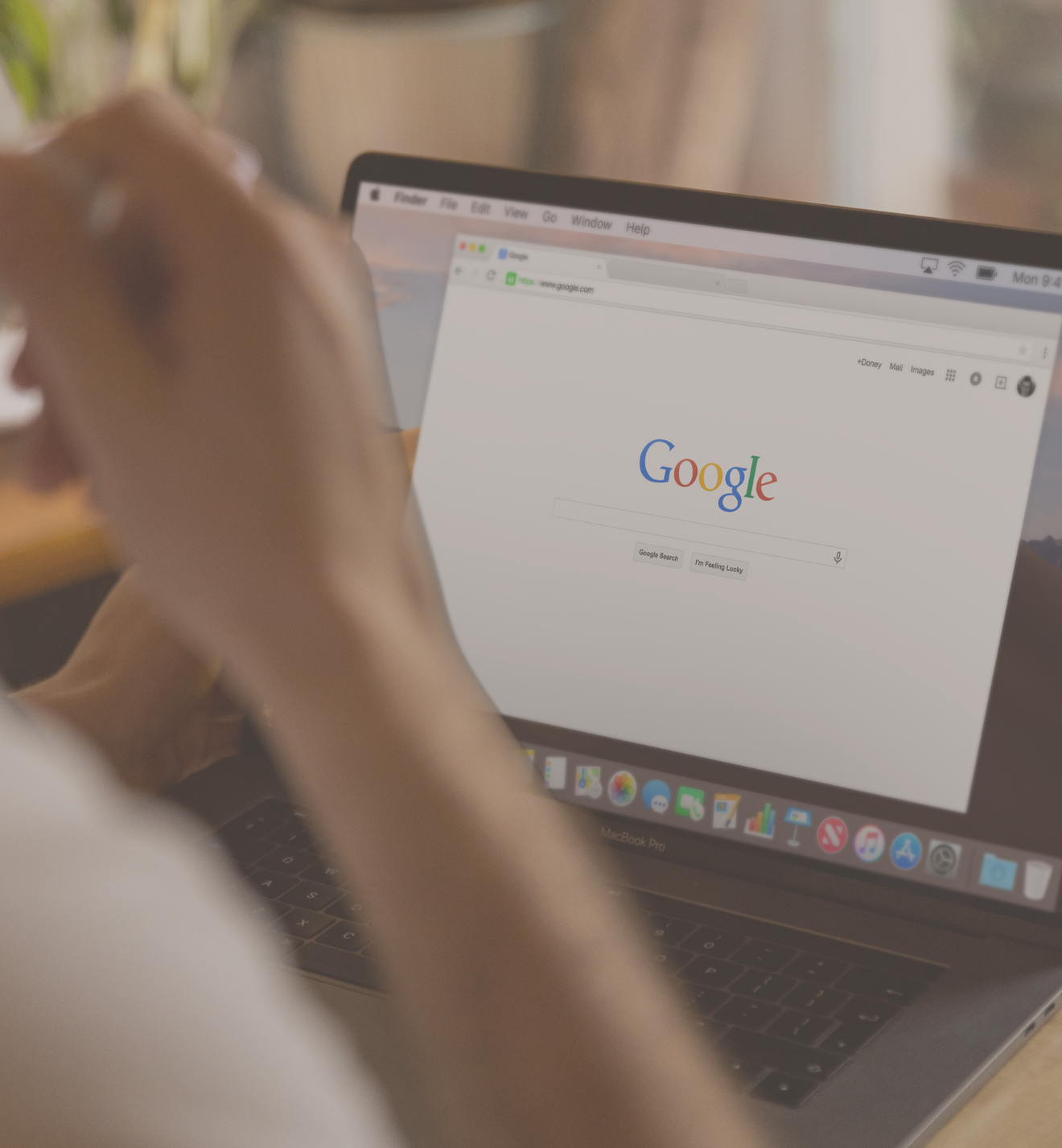 A person browsing Google search results on their MacBook, focusing on SEO and advertising.