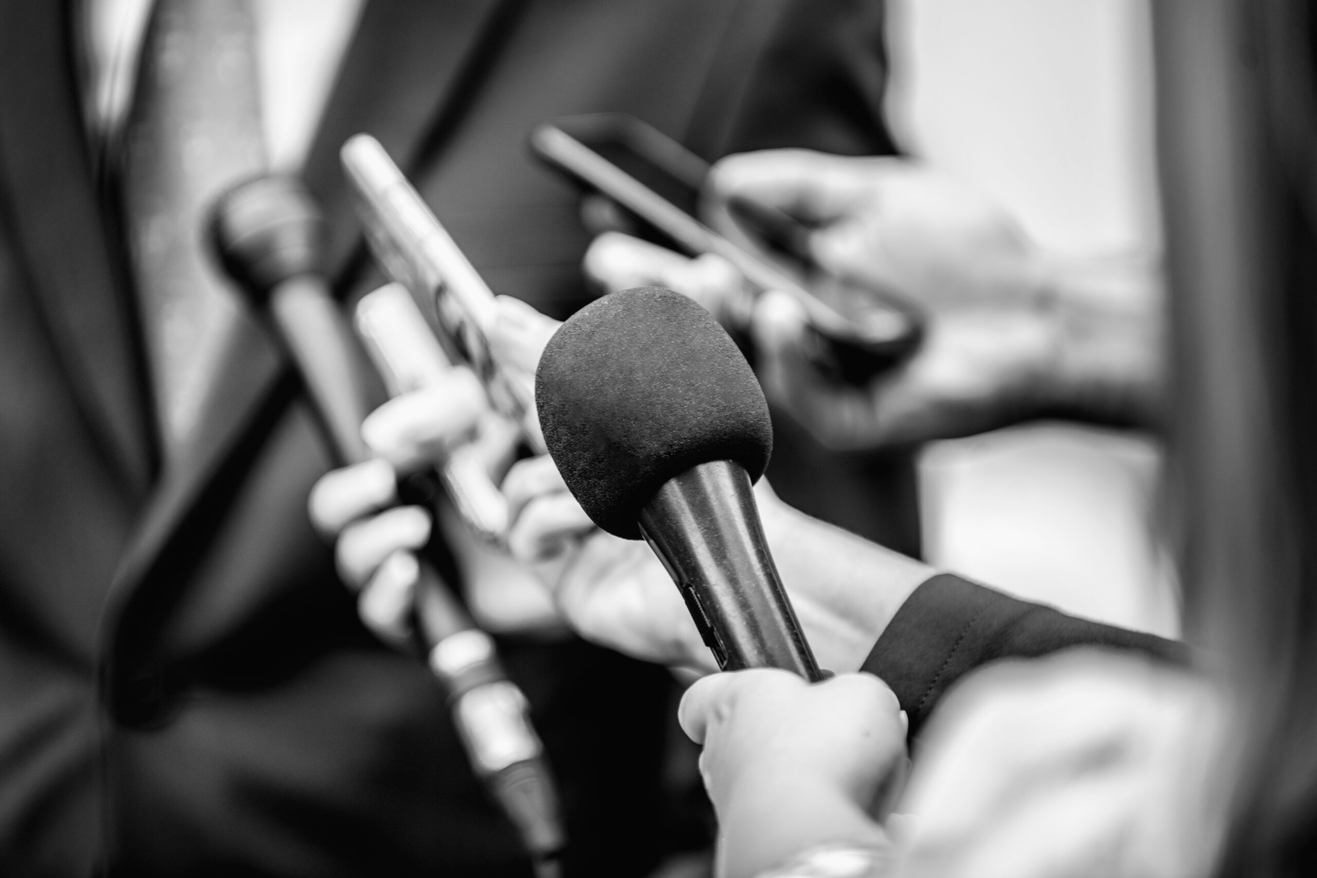 Media Interview - journalists with microphones interviewing formal dressed politician or businessman.